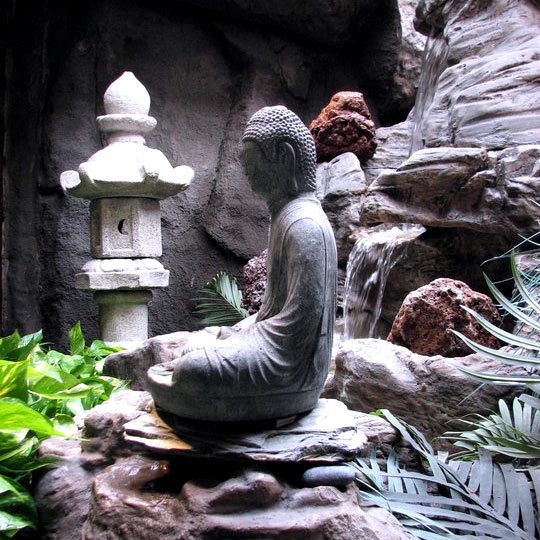 Stone Buddha statue beside the lobby waterfall
