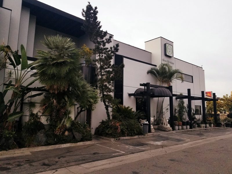 The building exterior with palms and pines along Oxford Avenue